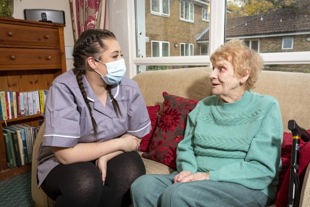 Resident and staff member having a conversation at Upper Mead Care Home