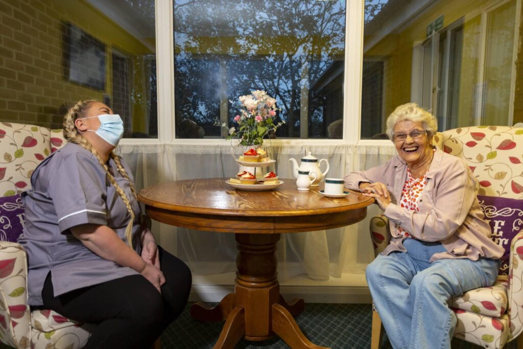 Resident and team member laughing