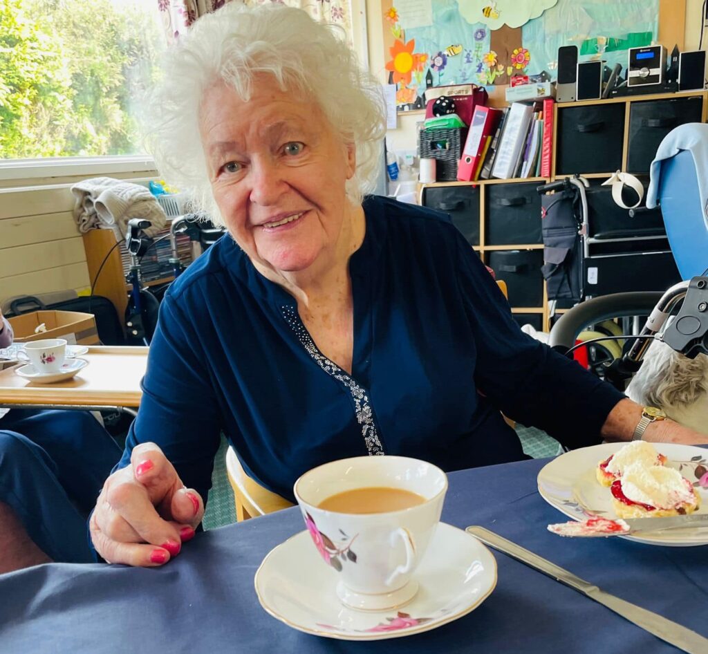 resident enjoying tea and scone