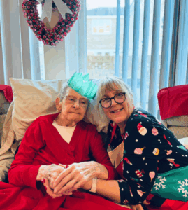 resident and staff sat together withChristmas hats on
